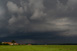 Durch die noch scheinende Sonne wirkt die Gewitterzelle sehr dunkel